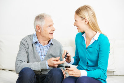 caregiver monitoring the blood sugar level of senior man