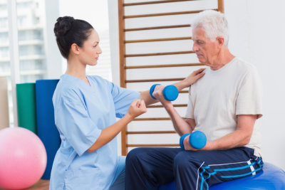 caregiver assisting the elder man doing exercise