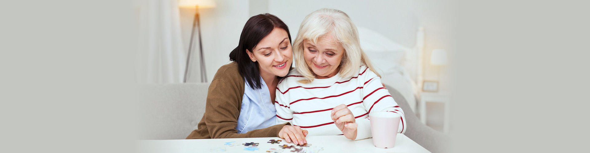 caregiver and senior woman playing a puzzle game