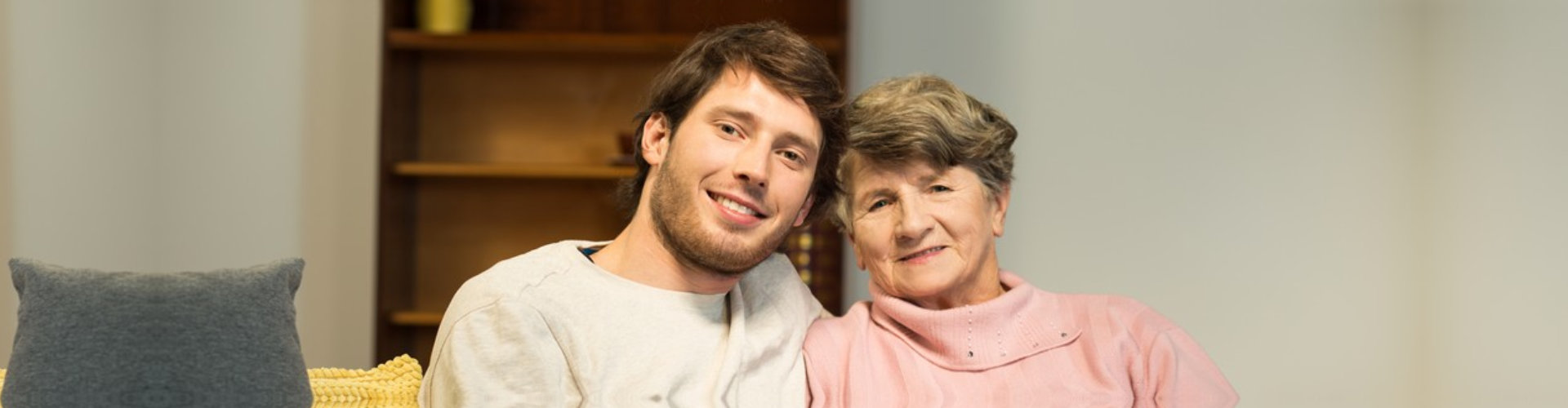 male caregiver and senior woman are smiling